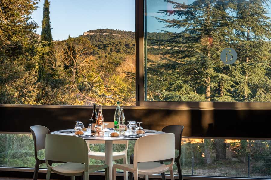 IMEO Studio - Accueil 5 Table dressée dans un restaurant avec vue panoramique sur les collines provençales.