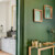 Vue d’une entrée décorée avec mur vert, miroir en bois et console design.