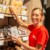 Employée de magasin Netto réapprovisionnant un rayon avec le sourire
