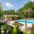 Maison de charme avec piscine et terrasse, entourée de végétation luxuriante.