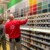 Vendeur en magasin de bricolage conseillant une cliente au rayon peinture.
